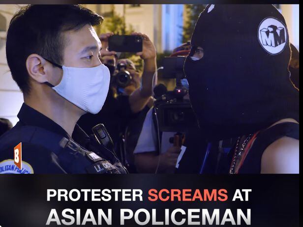 복면을 쓰고 한국어로 말하는 여성이 워싱턴에서 한국계로 추정되는경찰관을 "돼지"라고 부르며 노려보는 등 조롱하고 있다.  /브레이트바르트 페이스북 